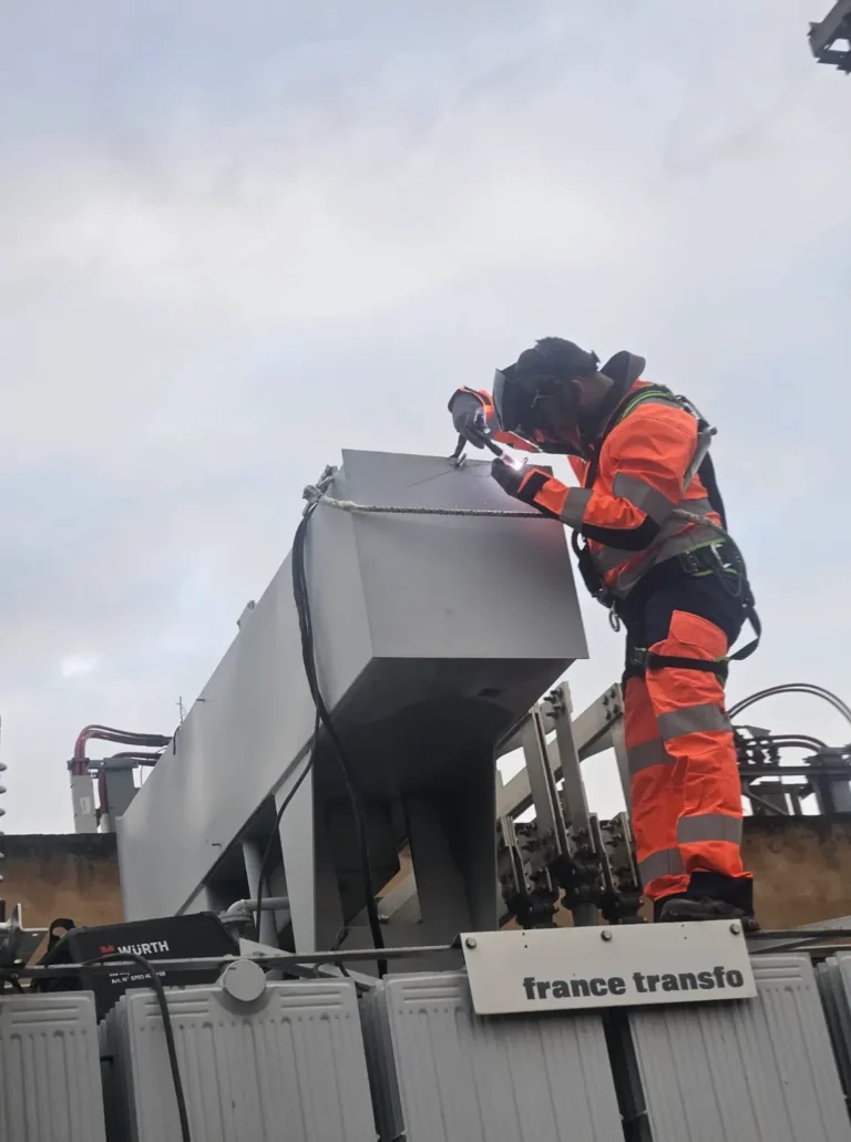 Technicien soudeur effectuant une intervention sur un transformateur HTB.