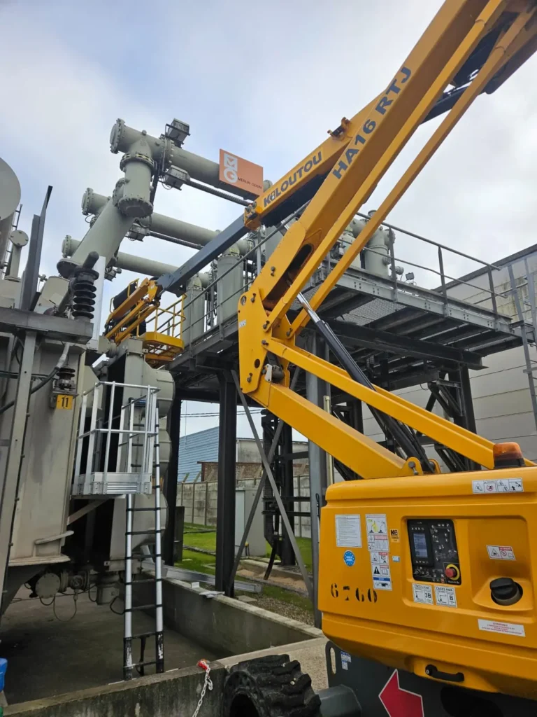 Techniciens en maintenance sur transformateur HTB à l'aide d'une nacelle élévatrice.
