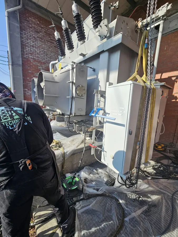 Technicien HTB effectuant des ajustements sur transformateur haute tension