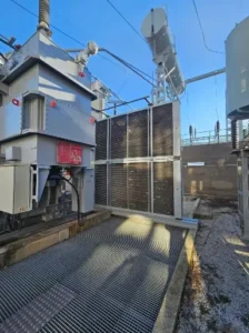 Vue des radiateurs et ventilateurs d’un transformateur haute tension en poste électrique HTB