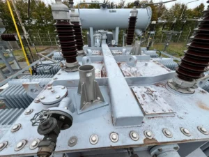Intervention de Height Technician in Building pour l'installation d'équipements de protection individuelle. Il s'agit là de la pose de deux embases Lumet (sans potence) sur un transformateur électrique. L'embase est un dispositif d'ancrage contre les chutes de hauteur.