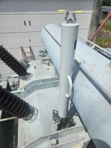 Intervention de Height Technician in Building pour l'installation d'équipement de protection individuelle. Il s'agit là de la pose d'une embase Miller avec potence (Honeywell) sur un transformateur électrique. L'embase et la potence sont des dispositifs d'ancrage contre les chutes de hauteur.