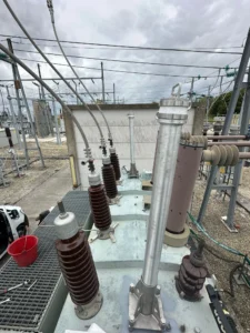 Intervention de Height Technician in Building pour l'installation d'équipements de protection individuelle. Il s'agit là de la pose de deux embases avec potence Lumet sur un transformateur électrique. Les embases et potences sont des dispositifs d'ancrage contre les chutes de hauteur.