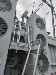 Intervention de Height Technician in Building sur un transformateur électrique pour la pose d'un équipement de protection collective.