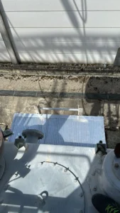 Intervention de Height Technician in Building pour l'installation d'une plateforme de départ d'échelle. Il s'agit là d'un moyen d'accès à la toiture d'un transformateur électrique. Intervention dans le cadre de travaux de sécurisation d'un transformateur contre les chutes de hauteur.