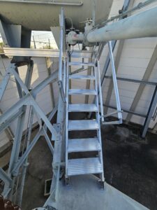 Intervention de la sarl Height Technician in Building (H.T.B) pour l'installation de moyens d'accès sur un transformateur électrique. Il s'agit là de la mise en place d'un escalier d'accès au conservateur. Intervention dans le cadre de travaux de sécurisation d'un transformateur électrique contre les chutes de hauteur.