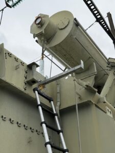 Intervention de Height Technician in Building pour la mise en place d'équipements de protection individuelle. Il s'agit là de mettre en place une ligne de vie horizontale rail, maintenue par trois supports Cupro. L'installation s'est faite sur le conservateur d'un transformateur. Ce sont là des dispositifs d'ancrage contre les chutes de hauteur.