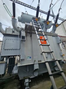 Intervention de Height Technician in Building pour l'installation d'une plateforme de départ d'échelle. Il s'agit là d'un moyen d'accès à la toiture d'un transformateur électrique. Intervention dans le cadre de travaux de sécurisation d'un transformateur contre les chutes de hauteur.