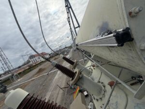 Intervention de Height Technician in Building pour la mise en place d'équipements de protection individuelle. Il s'agit là de mettre en place une ligne de vie horizontale rail, maintenue par trois supports Cupro. L'installation s'est faite sur le conservateur d'un transformateur. Ce sont là des dispositifs d'ancrage contre les chutes de hauteur.